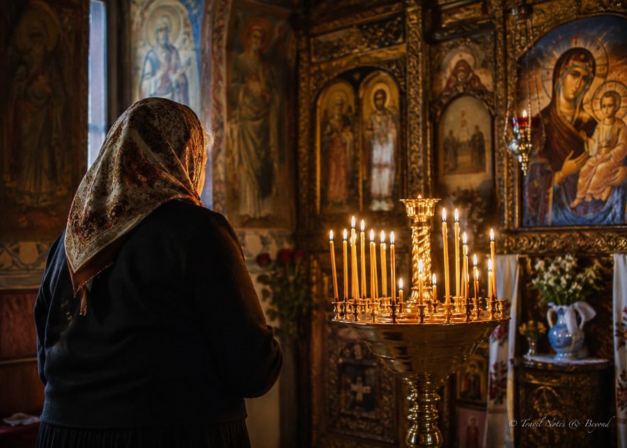 Old lady praying in Orthodox Church in Romania