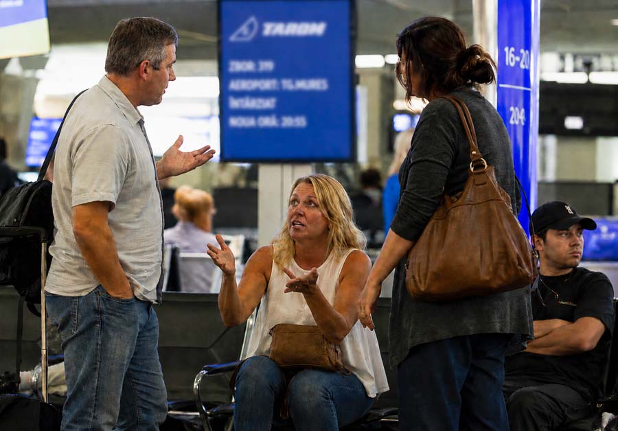 Romanians engaging in a conversation with strangers at the airport