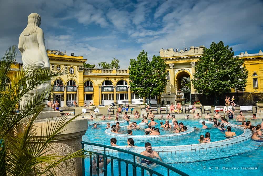 image of the outside pool with people swimming at the Szechenyi Baths in Budapest