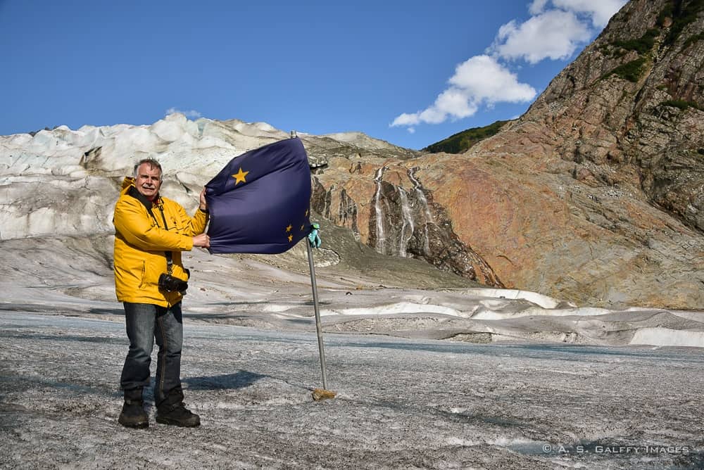 men holding a flag on the glacier