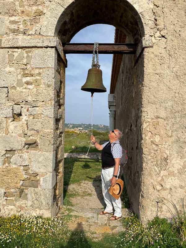 ringing a bronze church bell in a stone archway in Europe