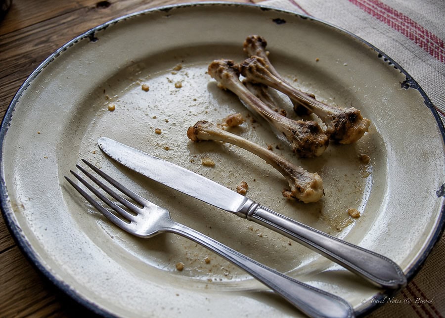 Empty plate with bones and a fork and a knife