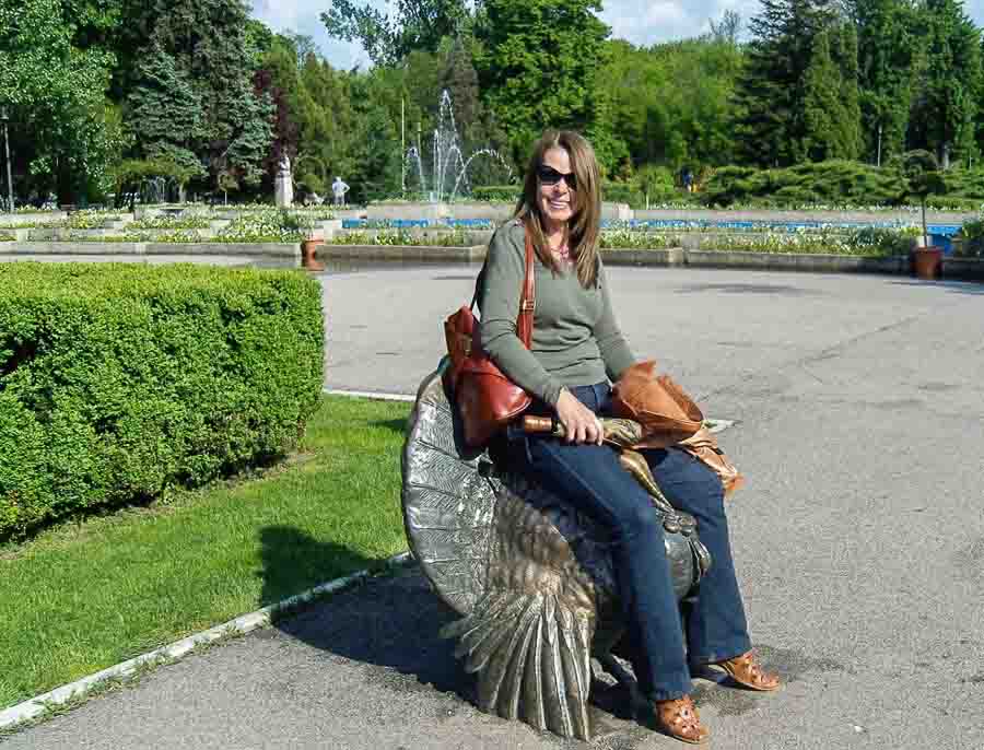 sitting on a bronze statue in Herastrau Park 