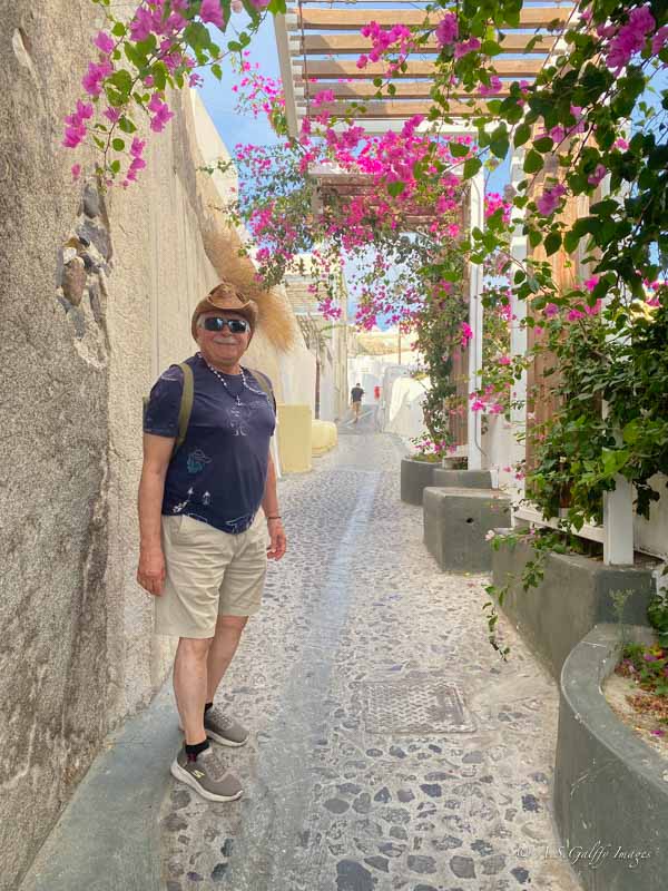 Men walk along a narrow alley in Santorini