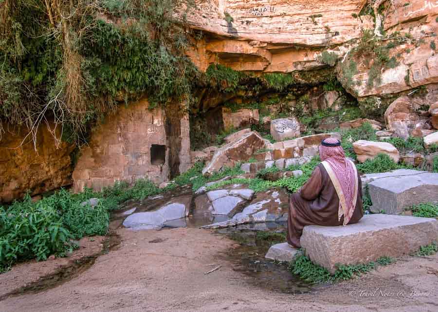 a Bedouin guide sitting in front of Lawrence's spring in Wadi Rum