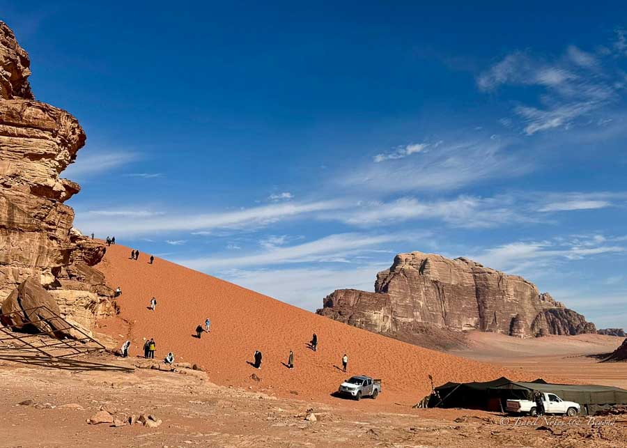 Tourists climbing the Red Sand Dunes in Wadi Rum