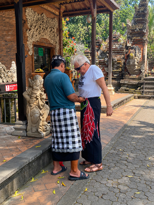 A man wearing a sarong at the entrance of a temple in Bali